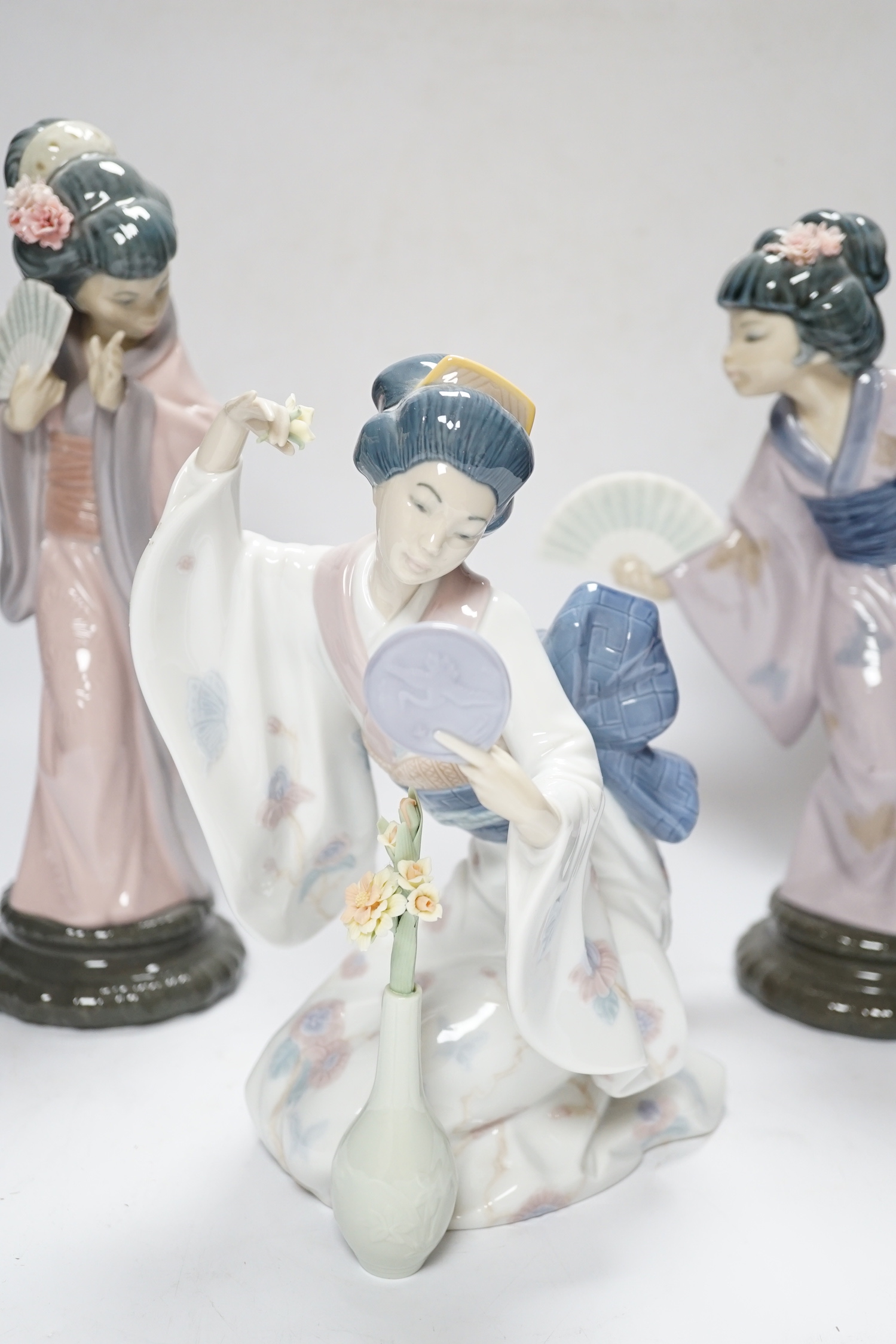 Three Lladro figures, Mirror Mirror, and two Japanese Geisha girls holding fans, (one boxed) tallest 29cm high